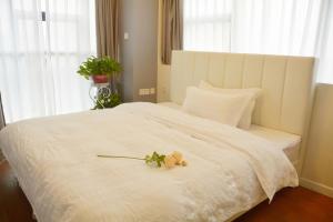 长沙悠闲的时光的卧室配有带鲜花的白色床