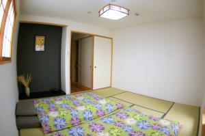 京都Vegan Minshuku Sanbiki Neko的一间卧室配有一张带彩色床罩的床