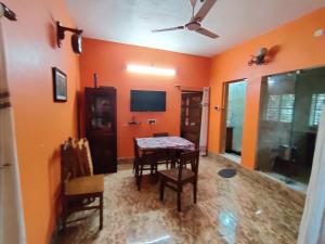 博尔普尔Abode of Peace的一间拥有橙色墙壁和桌椅的用餐室