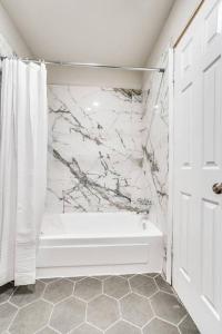 大草原城Mpressive Retreat!的白色的浴室设有白色的淋浴帘和浴缸。