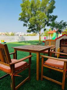 马斯喀特Abu Rakan Apartment的一张带两把椅子的木餐桌和游戏室