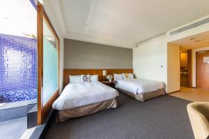 中坜南方庄园度假饭店的酒店客房设有两张床和窗户。