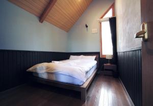 二世古Goodfellas Onsen House的一间带床的卧室,位于带窗户的房间内