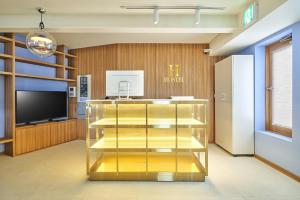 首尔H HOSTEL Itaewon的大堂设有金色展示盒和电视