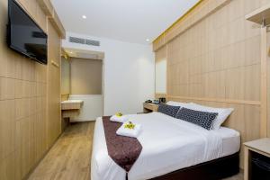 新加坡Hotel 81 Premier Star的卧室配有一张大床,墙上配有电视