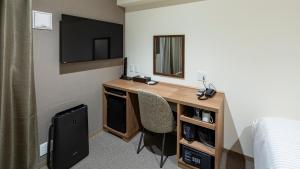 福冈Hotel Reference Tenjin III的客房设有书桌、镜子和床。