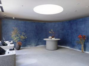 金泽SOKI Kanazawa的一间设有一张桌子和鲜花的蓝色墙壁客房