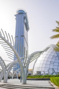 迪拜Ultra Luxury Palm Tower with Shared 5 Star Hotel Facilities的一座高大的建筑,前面有一棵棕榈树