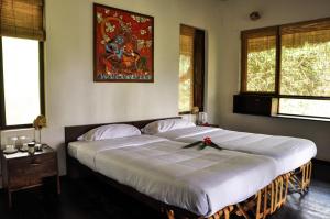 瓦亚纳德Uravu Bamboo Grove Resort的一间卧室配有一张大床,上面有弓