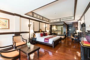 华欣Wora Bura Hua Hin Resort & Spa - SHA Extra Plus的酒店客房设有床和客厅。