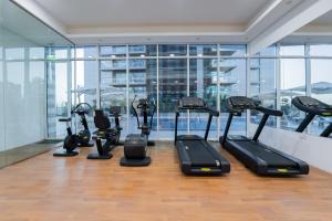 迪拜Kasco Homes Waves Tower Business Bay的健身房设有数台跑步机和椭圆机