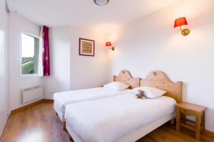 吕格兰Garden & City Evian - Lugrin的两间位于酒店客房的床,上面有泰迪熊