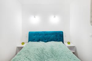 什切尔克Apartament Ale Widok的一张带蓝色床头板的睡床