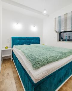 什切尔克Apartament Ale Widok的卧室内的一张带蓝色床头板的大床
