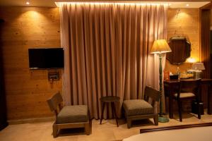 PanhālaAATHAVAN MATICHI ECO RESORT的酒店客房配有桌椅和电视。
