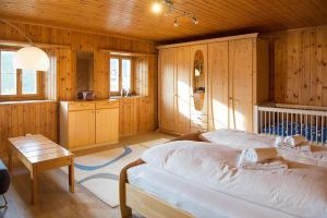 SchmittenHaus Schmitten - Davos的一间卧室设有木墙、一张床和一张桌子