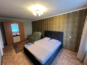 巴甫洛达尔Стандарт Камзина 74 г. Павлодар的一间卧室配有一张床和一把椅子