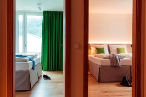 厄茨All-Suite Resort Ötztal的一间卧室设有两张床和绿帘