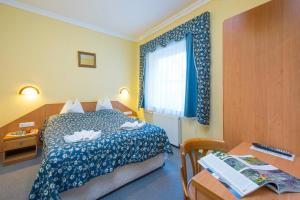 米什科尔茨道波曹基柯勒特俱乐部酒店的一间卧室配有一张床、一张书桌和一个窗户。