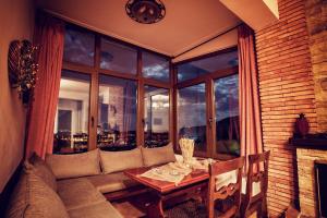纳乌萨玛西亚斯米利特萨宾馆的客厅配有沙发和窗户前的桌子
