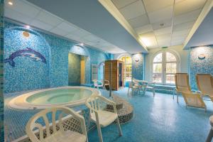 米什科尔茨道波曹基柯勒特俱乐部酒店的一间带浴缸的浴室,位于一间拥有蓝色墙壁的客房