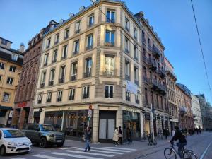 斯特拉斯堡Résidence 12 Rue de la Mesange - City Center的一条城市街道上一座大型建筑,人们穿过街道