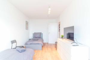 美茵河畔哈瑙Chic City-View Apartments in Hanau的配有白色墙壁和木地板的客房内的两张床