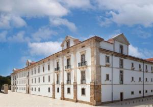 阿尔科巴萨Montebelo Mosteiro de Alcobaça Historic Hotel的一座白色的大建筑,背后是蓝天