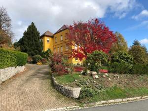 勒奥瓦尔德Loft mon Soleil的黄色的房子,树上有红色的叶子