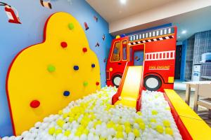罗东镇童玩樂親子旅宿Toy Fun Hotel的游戏室,带玩具消防车的球坑