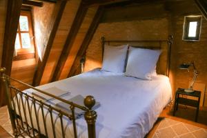 勒比格La Petite Maison的一间卧室配有带白色床单和枕头的床。