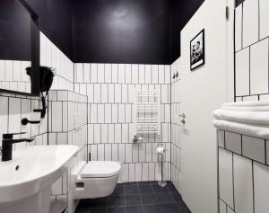 布达佩斯Metropolis Budapest Boutique Hotel的黑白浴室设有卫生间和水槽