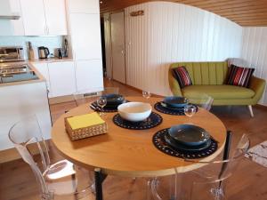 莱斯拉塞斯Apartment Cassiopée 26 by Interhome的厨房里一张木桌,上面放有盘子和碗