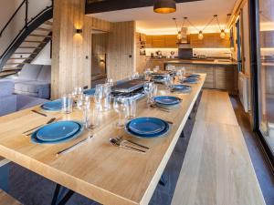 圣热尔韦莱班Holiday Home L'Adret by Interhome的厨房里一张长桌,上面有蓝色的盘子和银器