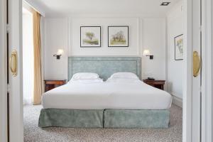 圣塞瓦斯蒂安伦德雷斯茵格拉特拉酒店的一间卧室配有一张带白色床单的大床