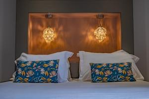 巴布哈兹La Maison Rouge的一间卧室配有带2个枕头和2盏灯的床