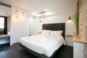 佩里格L' échafaud - Apparts de standing - Centre historique的一间卧室配有一张带白色床单的大床