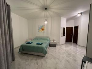 泽布季Gozo - 3 Bedroom - Brand New的一间白色客房内的绿色床卧室
