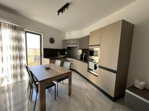 泽布季Gozo - 3 Bedroom - Brand New的一间带木桌的厨房和一间餐厅