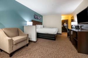 杰克逊维尔Sleep Inn Jacksonville Airport的配有一张床和一把椅子的酒店客房