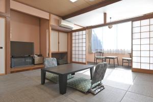 富士河口湖Kawaguchiko Park Hotel的客厅配有桌椅