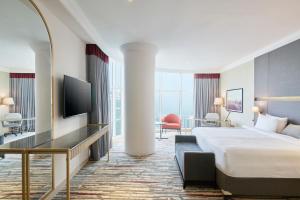 多哈Ramada by Wyndham Doha Old Town的酒店客房,配有床和电视