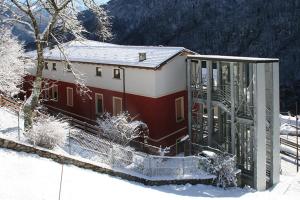 PaiscoForesteria Giardino的雪中带门的红白建筑
