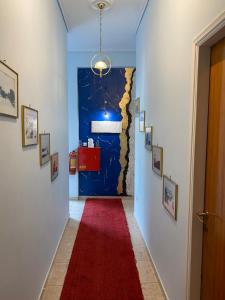 卡拉马塔乔治酒店 的走廊上铺有红地毯,设有蓝色的墙壁