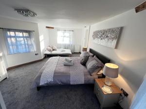 奇德尔Tollgate House - Luxury Cozy Cottage - HUGE Hot Tub - Alton Towers的一间卧室配有一张床和一张带台灯的桌子