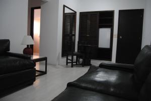 埃斯特角城伊比利亚酒店的客厅配有黑色皮革家具和镜子