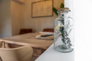 登堡Bed & Bos de 14 Sterren的一张桌子上装有鲜花的玻璃瓶