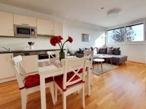 维也纳Near Lake Stylish & Fully Furnished Apartment的厨房以及带桌椅的起居室。