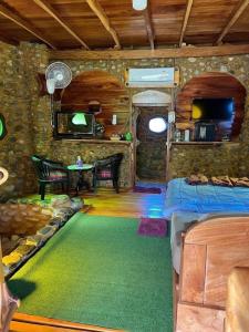 Ban Tha Phaeลีลา โฮมสเตย์ Leela Homestay的一间设有床铺的房间和一间铺有绿色地毯的房间