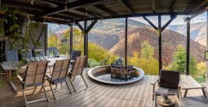 Muntele ReceAmonte Mountain Resort的山景甲板配有桌椅